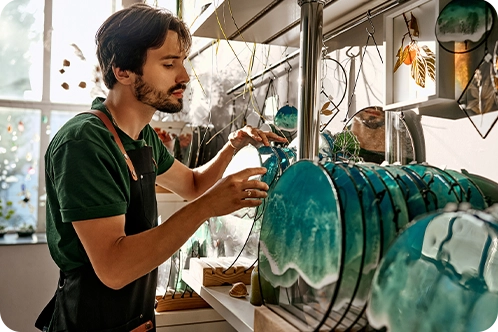 artist shop owner setting up his artwork in his store