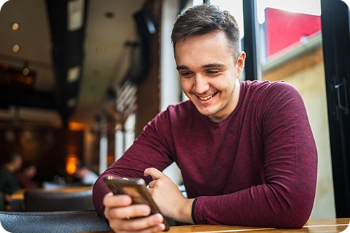 man looking at phone in restaurant