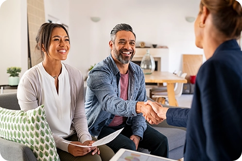 couple shaking hands with wealth advisor