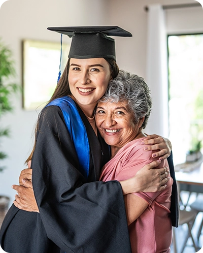 granddaughter in her cap and gown hugging her grandmother