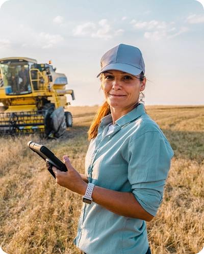 female farmer out in field with equipment behind her