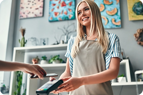 woman smiling as she takes money from customer