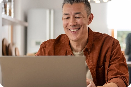 man smiling while looking at computer