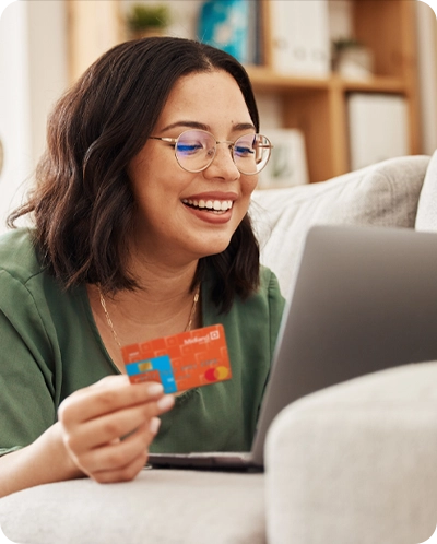 woman smiling as she shops online with a Midland debit card