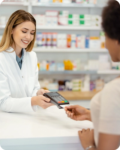 pharmacist assisting customer with paying with their debit card