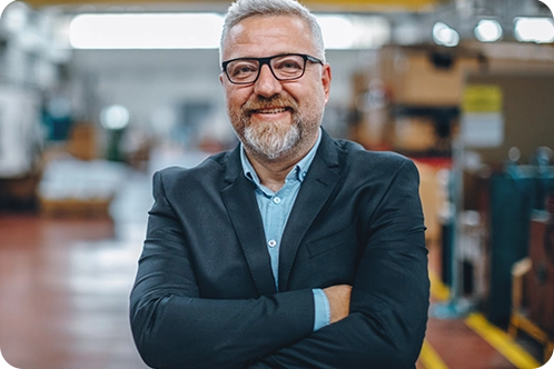 older man smiling at camera while standing in his print shop