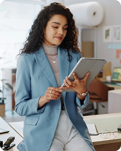 woman small business owner standing in her shop looking at a tablet