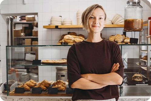 smiling small business woman standing in her bakery