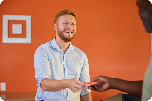 male bank teller taking money from customer