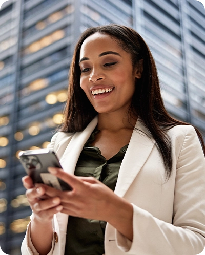 Business woman smiling as she looks at her phone