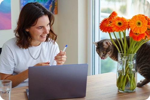 woman working from home with cat joining her