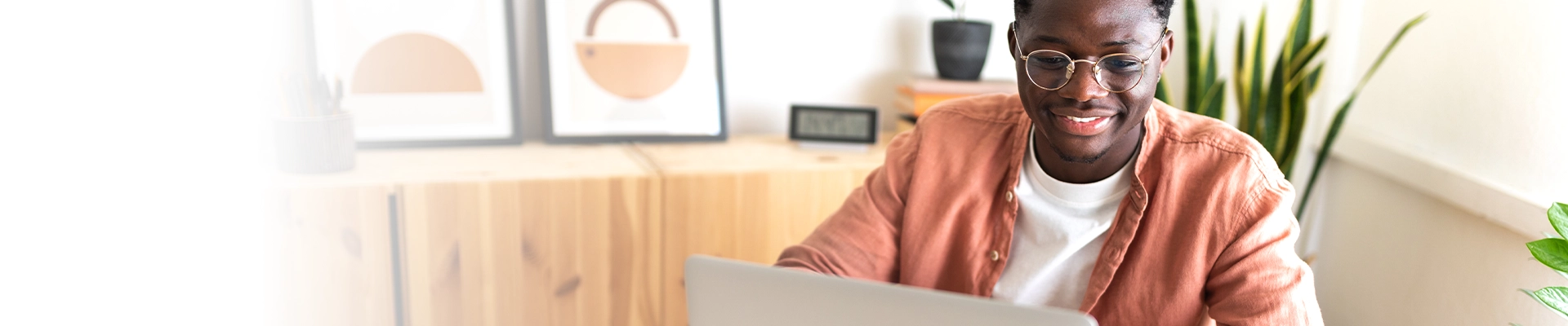 younger man smiling as he works on computer